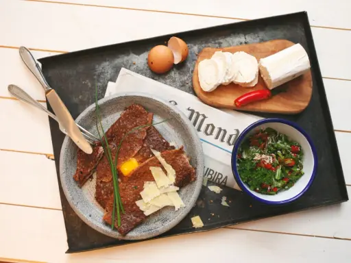 Herzhafte Galette Bretonne mit Ei, Käse und Salat, dazu Ziegenkäse und Chili.