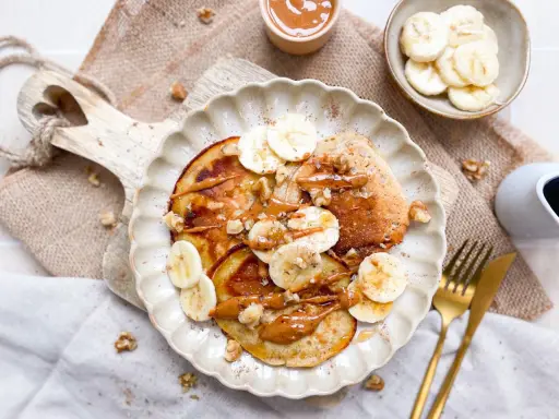 Leckere bananen pancakes ohne ei, garniert mit Bananenscheiben, Nüssen und einer cremigen Sauce. Ein Genuss für jeden Morgen!
