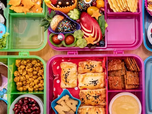 Bunte Bento-Boxen mit Sushi, Obst, Keksen und Gebäck. Perfekt für to go rezepte und kleine Entdecker.