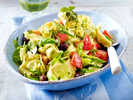 Ein bunter Tortellinisalat mit frischen Tomaten, Oliven, Basilikum und einem leckeren Pesto.