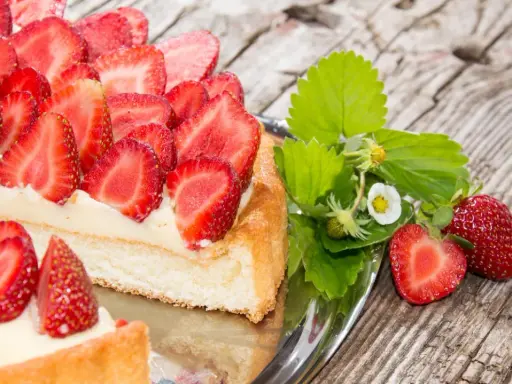 Ein köstlicher Erdbeerkuchen mit frischen Erdbeeren und Sahne auf einem Silbertablett. Perfekt für ein Erdbeerkuchen Rezept.