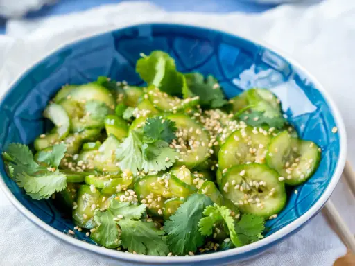 Erfrischender Gurkensalat asiatisch, garniert mit Koriander und Sesam. Ein leichter Genuss!