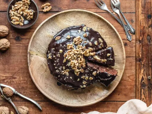 Saftiger Walnusskuchen ohne Mehl, glasiert mit Schokolade und garniert mit Walnüssen. Ein Genuss für alle Sinne!