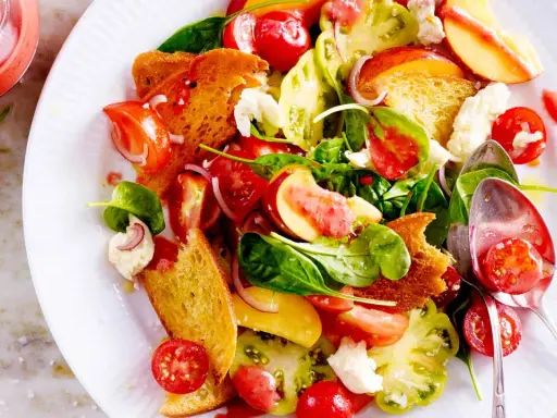 Bunter Salat mit Tomaten, Pfirsich, Brot und Käse – ein Fest für die Sinne und ein Beispiel für raffinierte Sommersalate.