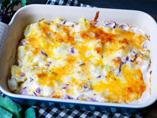Herzhaftes rezept kohlrabi-auflauf vegetarisch mit geschmolzenem Käse und Kräutern in einer Auflaufform.