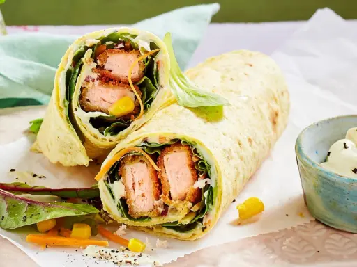 Leckere Wraps selber machen: knuspriger Lachs, frischer Salat, Mais und Karotten in einem Tortilla-Wrap, dazu ein Dip.