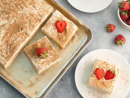 Saftiger Tres Leches Kuchen, bestreut mit Zimt und garniert mit frischen Erdbeeren. Ein Genuss für jeden Anlass.