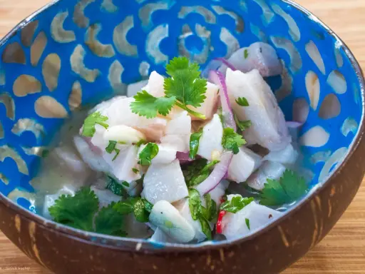 Frisches Ceviche im Kokosnussschalen-Schälchen, garniert mit Koriander. Ein authentisches Ceviche Rezept original, das Lust auf mehr macht.