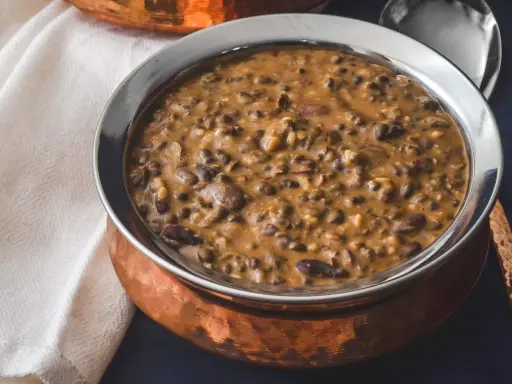Cremiges Dal Makhani in einer Kupferschale, serviert mit einem Löffel.