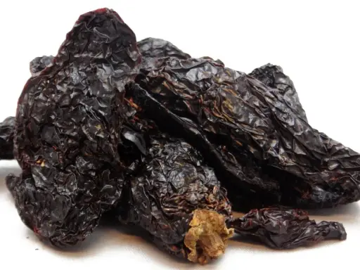 Getrocknete, dunkelrote Chilis, die Frage "was ist Chipotle?" beantwortend. Sie sind die Basis für rauchige Saucen und Gewürze.