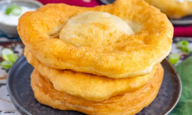 Goldbraune, fluffige Langos stapeln sich auf einem Teller. Ein köstliches Langos Rezept für zu Hause.