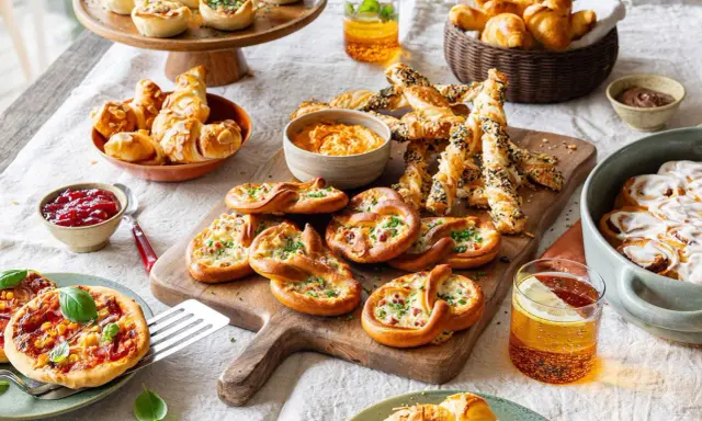 Herzhafte Snacks: Brezeln mit Käse und Speck, Mini-Pizzen, Blätterteigstangen und kleine Quiches laden zum Genießen ein.