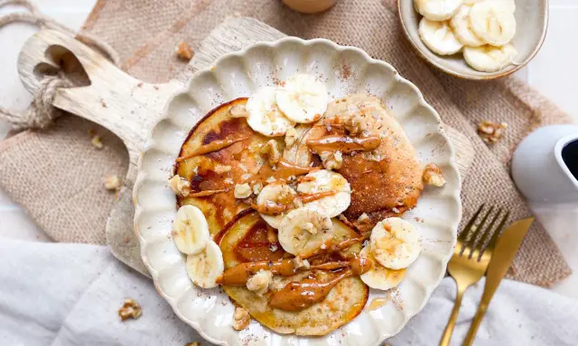 Leckere bananen pancakes ohne ei, garniert mit Bananenscheiben, Nüssen und einer cremigen Sauce. Ein Genuss für jeden Morgen!