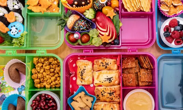 Bunte Bento-Boxen mit Sushi, Obst, Keksen und Gebäck. Perfekt für to go rezepte und kleine Entdecker.