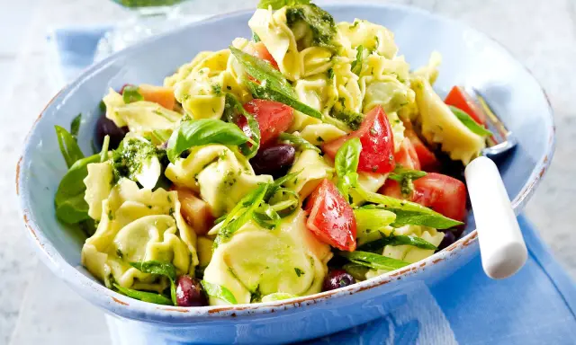 Ein bunter Tortellinisalat mit frischen Tomaten, Oliven, Basilikum und einem leckeren Pesto.
