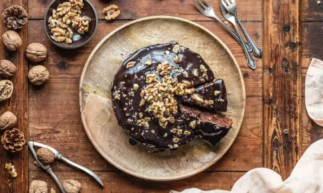 Saftiger Walnusskuchen ohne Mehl, glasiert mit Schokolade und garniert mit Walnüssen. Ein Genuss für alle Sinne!