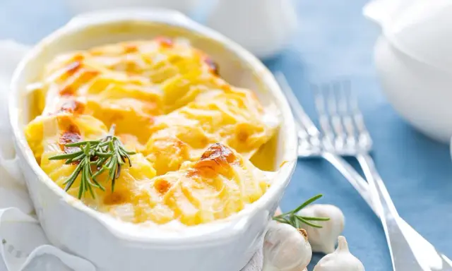Ein goldbrauner Kartoffelauflauf mit Rosmarin und Knoblauch, bereit zum Servieren. Ein köstliches Auflauf Rezept für jeden Anlass.