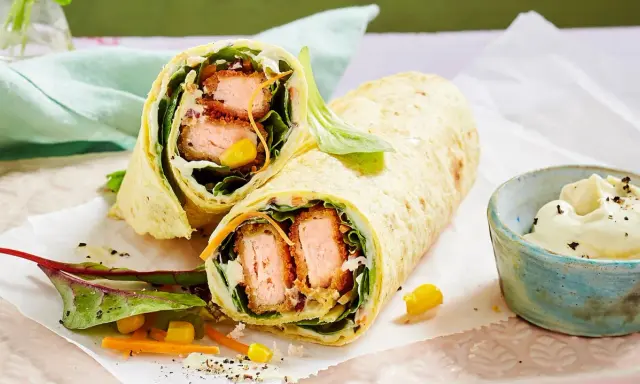 Leckere Wraps selber machen: knuspriger Lachs, frischer Salat, Mais und Karotten in einem Tortilla-Wrap, dazu ein Dip.