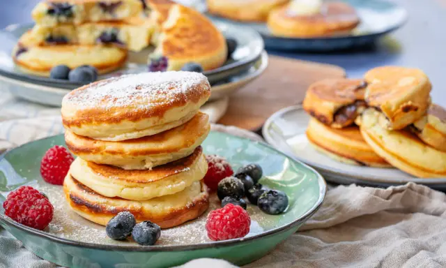 Fluffige Buttermilch Pancakes, mit Puderzucker bestäubt und garniert mit frischen Beeren. Ein Genuss für jeden Morgen!