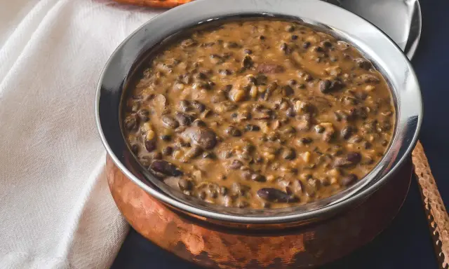 Cremiges Dal Makhani in einer Kupferschale, serviert mit einem Löffel.