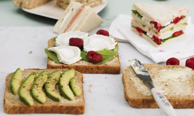 Schnelles Essen ohne Kochen: Mehrere belegte Brote mit Avocado, Ziegenkäse und Himbeeren, bereit zum Genuss.