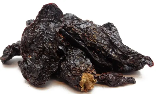 Getrocknete, dunkelrote Chilis, die Frage "was ist Chipotle?" beantwortend. Sie sind die Basis für rauchige Saucen und Gewürze.