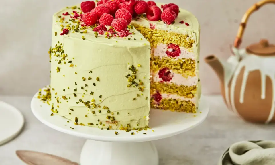 Himbeer-Pistazien-Torte mit frischen Beeren und grüner Creme, ein köstlicher Genuss.
