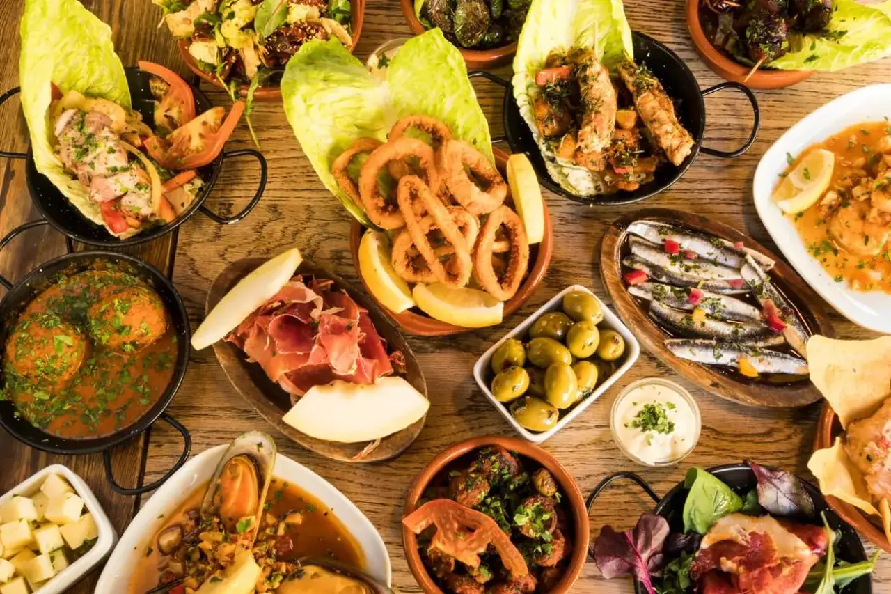 Vielfalt an Tapas: Tintenfischringe, Sardinen, Oliven, Fleischb&auml;llchen, Garnelen, Schinken und mehr &ndash; perfekt, um Tapas selber machen zu lernen.