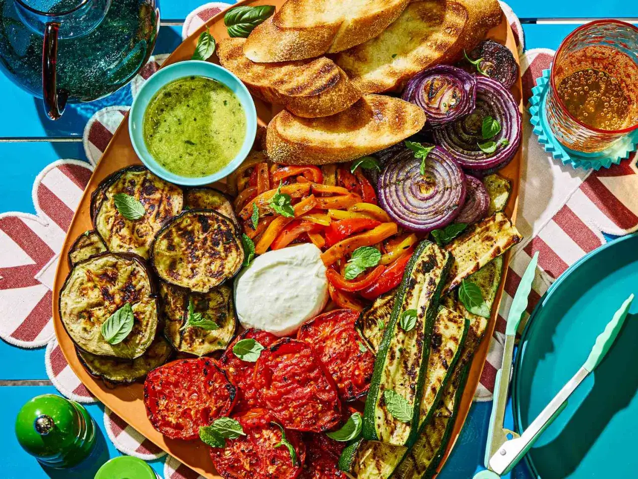 Bunte Grillbeilagen: Gegrillte Auberginen, Zucchini, Paprika, Tomaten und Zwiebeln mit Brot und Dip. Perfekt f&uuml;r ein Sommerfest.