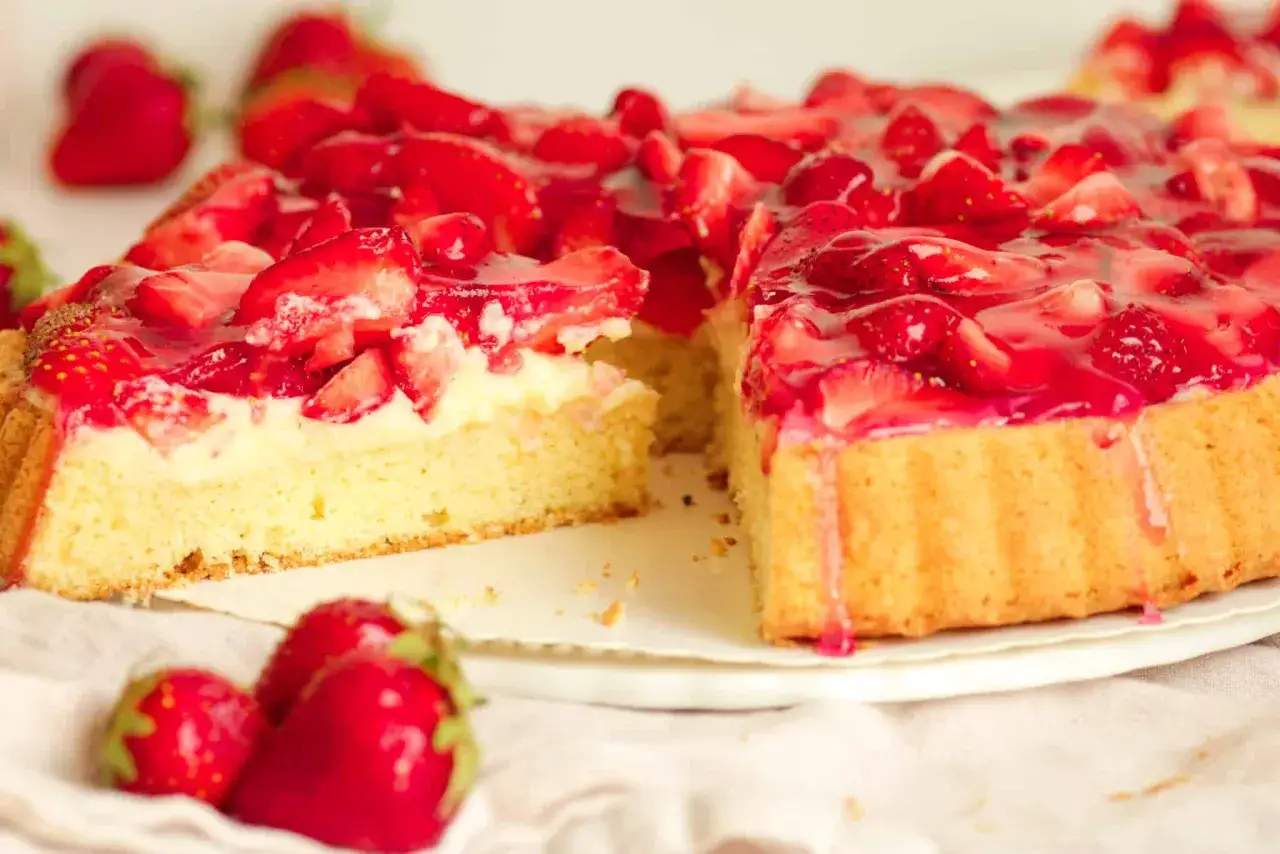 Ein saftiger erdbeerkuchen mit vanillepudding und frischen Erdbeeren, der zum Genie&szlig;en einl&auml;dt.