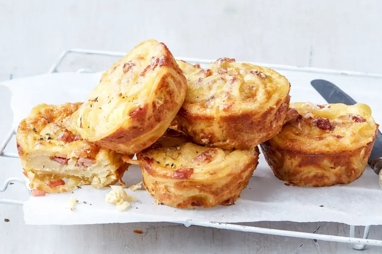 Herzhafte Snacks schnell und einfach: goldbraune Kartoffel-Speck-Muffins auf einem Gitter.