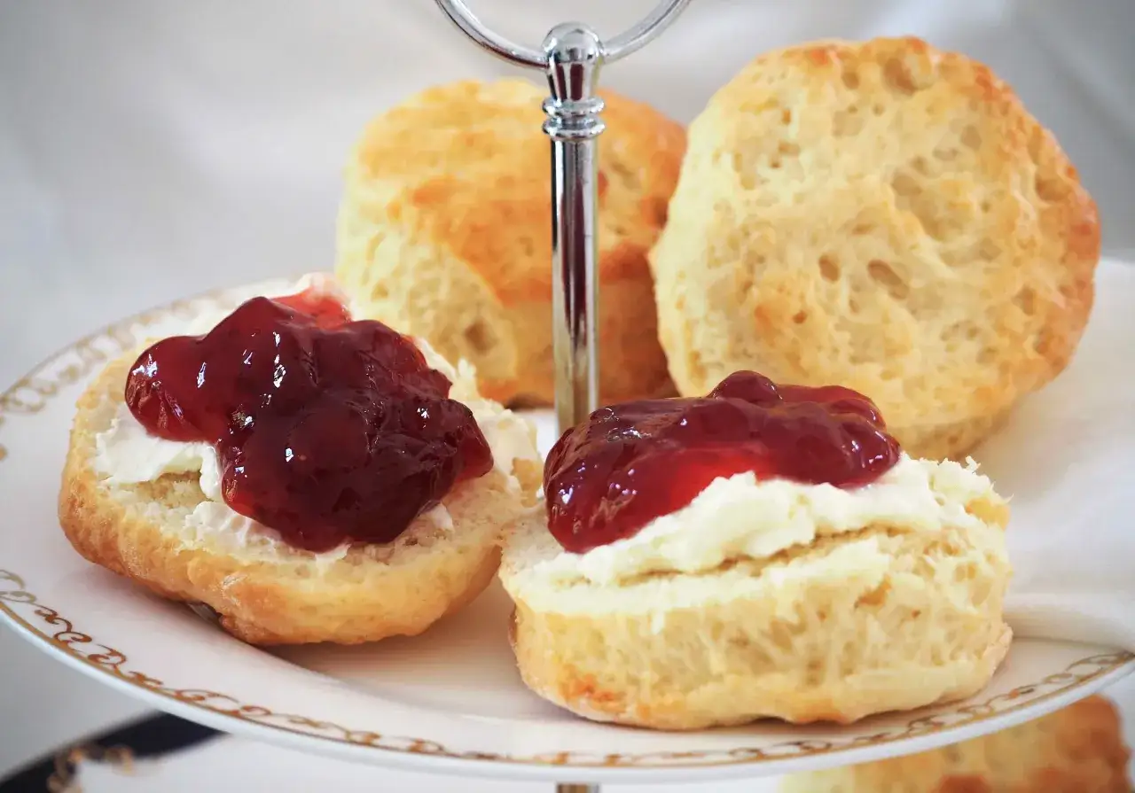 Zwei Scones mit Clotted Cream und Marmelade auf einer Etagere. Ein k&ouml;stliches Rezept f&uuml;r Scones, perfekt f&uuml;r den Nachmittagstee.