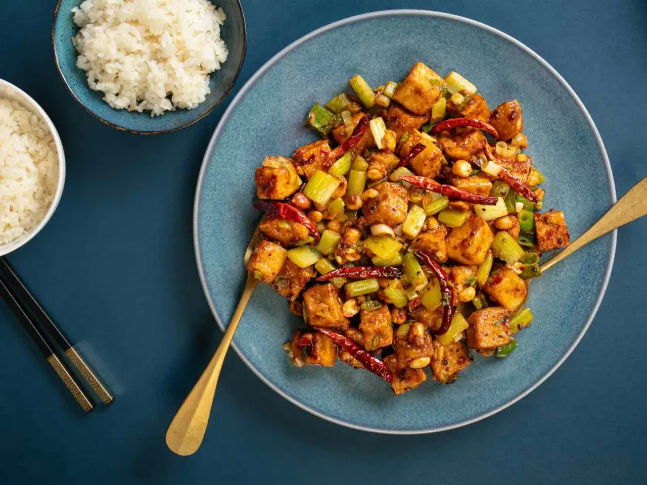 W&uuml;rziges Gericht mit Tofuw&uuml;rfeln, Sellerie und Erdn&uuml;ssen, perfekt f&uuml;r Rezepte mit Tofu natur. Dazu Reis und St&auml;bchen.
