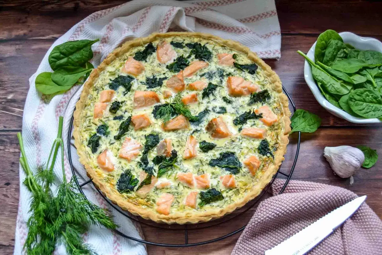 Herzhafte Lachs Spinat Quiche mit frischem Dill, bereit zum Servieren.