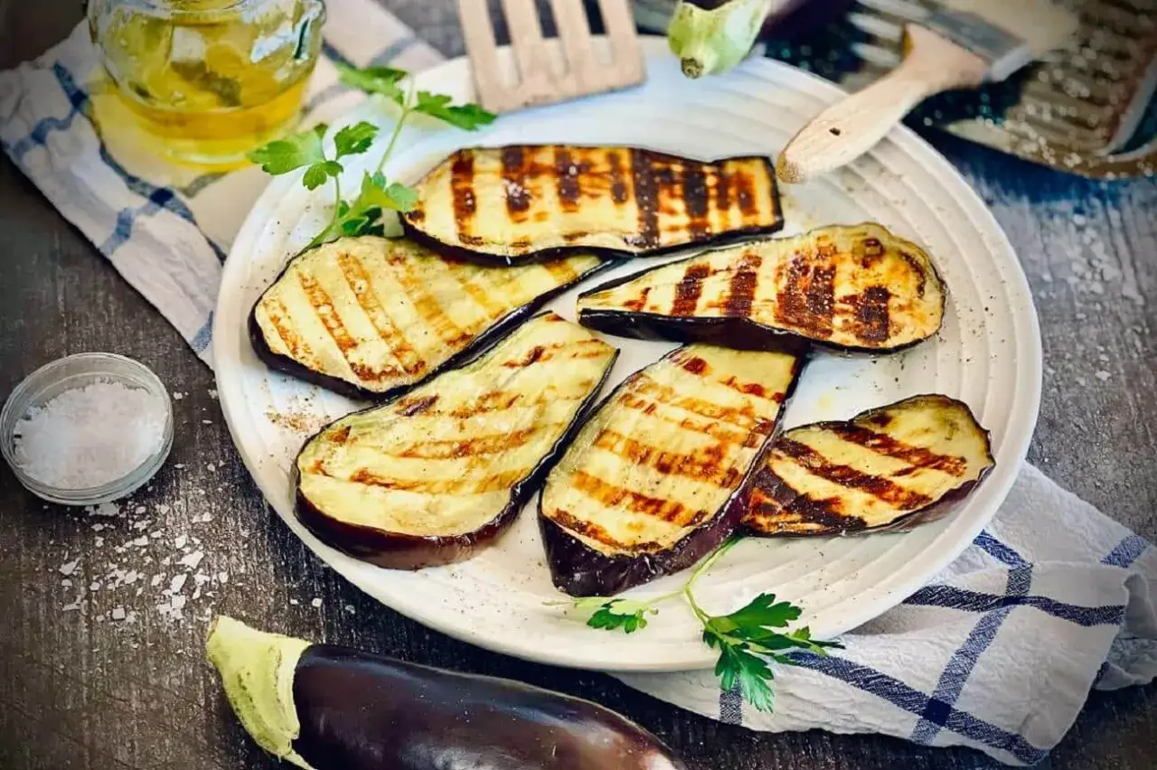 Gegrillte Auberginenscheiben mit Schale, garniert mit Petersilie. Perfekt zum Aubergine mit Schale essen.