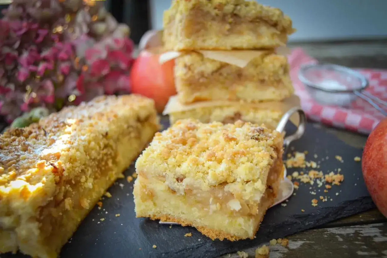 Saftiger Apfelkuchen vom Blech mit Streuseln, frisch gebacken und bereit zum Genie&szlig;en.