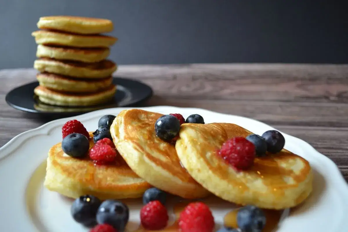 Fluffige Pancakes mit Beeren und Sirup, ein k&ouml;stliches Pancakes Rezept f&uuml;r den perfekten Start in den Tag.