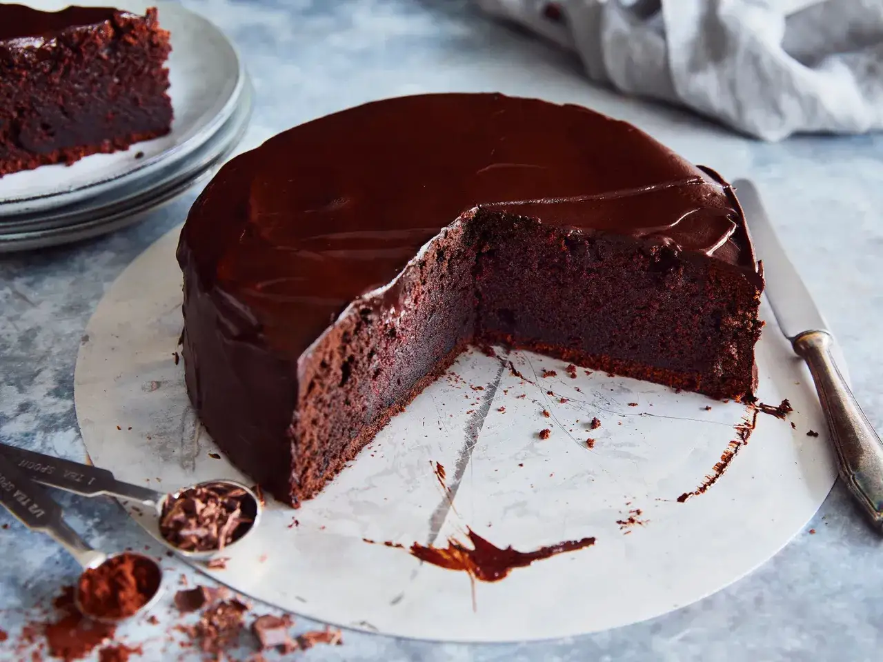 Saftiger Schokoladenkuchen mit gl&auml;nzender Glasur, ein Genuss f&uuml;r alle Schokoladenkuchen Rezepte Liebhaber. Ein St&uuml;ck fehlt bereits.