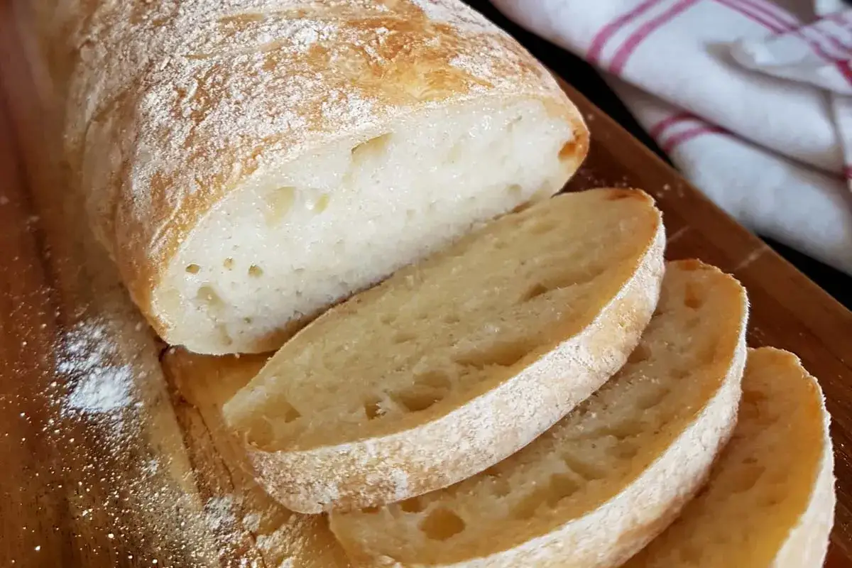 Frisch gebackenes Ciabatta Brot, aufgeschnitten auf einem Holzbrett. Ein tolles Ciabatta Rezept f&uuml;r zu Hause.