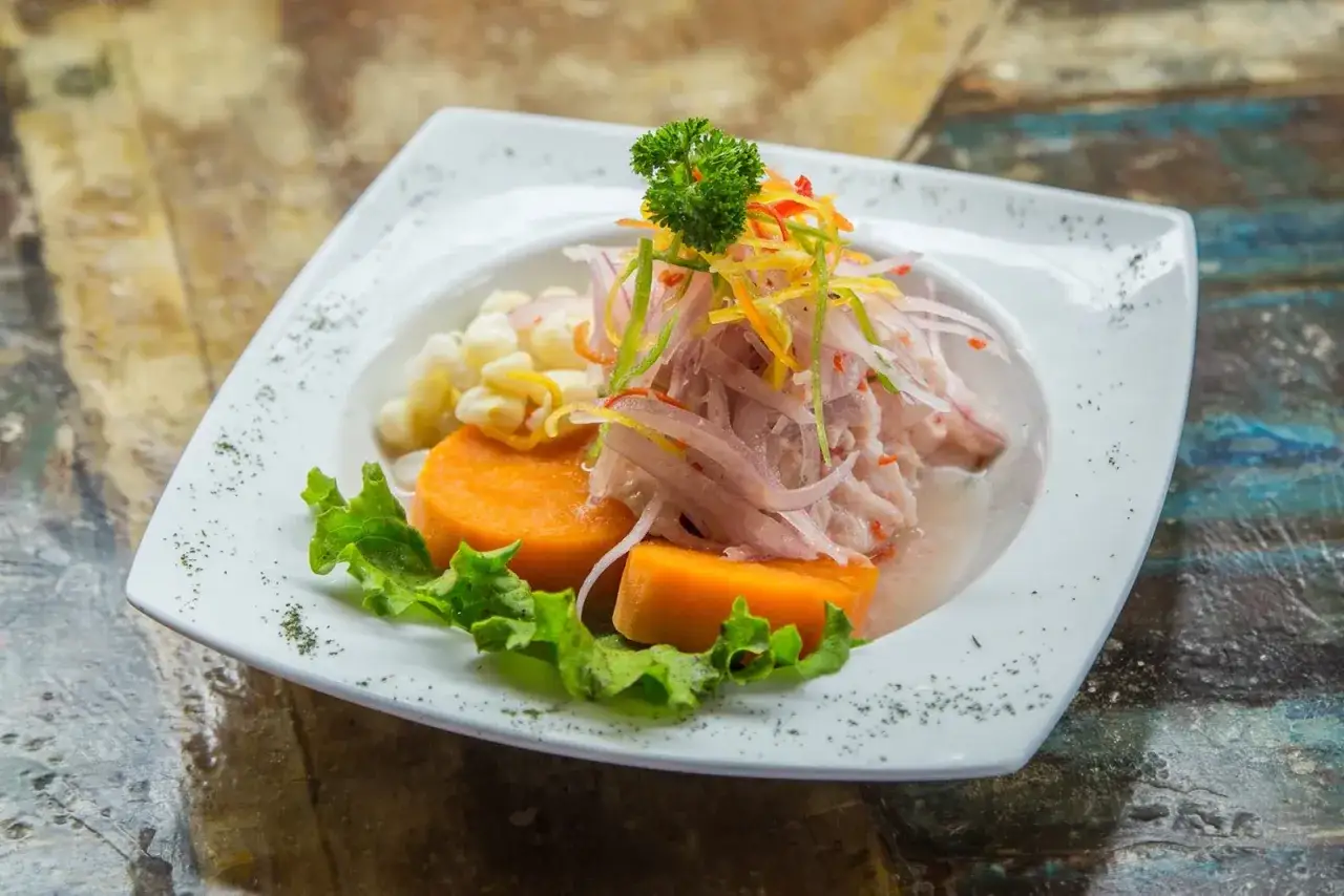 Ein authentisches Ceviche Rezept Original: Frischer Fisch, S&uuml;&szlig;kartoffel, Mais und Zwiebeln auf einem Teller.