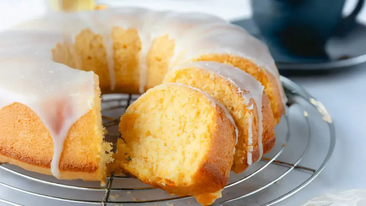 Saftiger Joghurtkuchen mit 500 g Joghurt, &uuml;berzogen mit s&uuml;&szlig;er Glasur. Ein St&uuml;ck ist bereits angeschnitten.