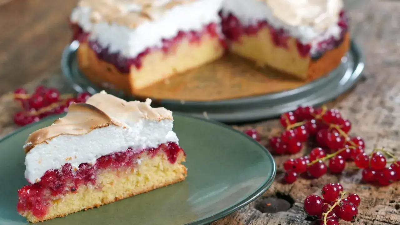Ein St&uuml;ck von Omas Johannisbeerkuchen mit Baiser, saftig und mit frischen roten Johannisbeeren belegt.