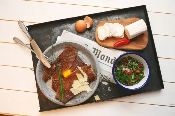 Herzhafte Galette Bretonne mit Ei, Käse und Salat, dazu Ziegenkäse und Chili.