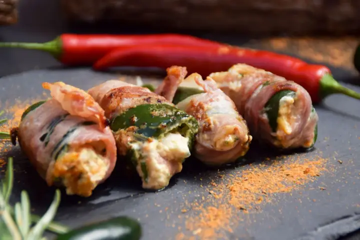 Gefüllte Jalapeños, umwickelt mit Speck, sind ein köstlicher Snack. Was sind Jalapeños? Kleine, grüne Chilis mit moderater Schärfe.