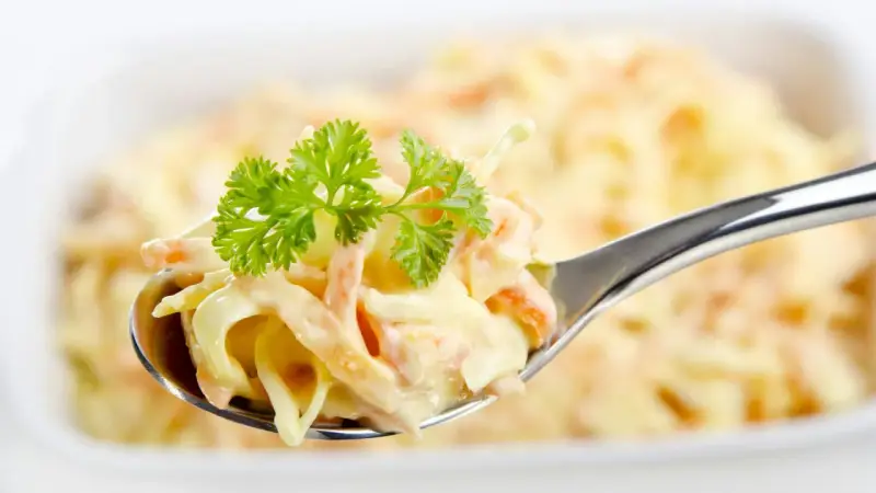 Ein Löffel cremiger Krautsalat, garniert mit Petersilie. Perfekt für jedes coleslaw rezept.